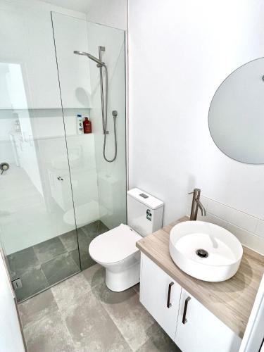 a bathroom with a toilet and a sink and a shower at Private Barwon Heads Cottage Walk to River in Barwon Heads