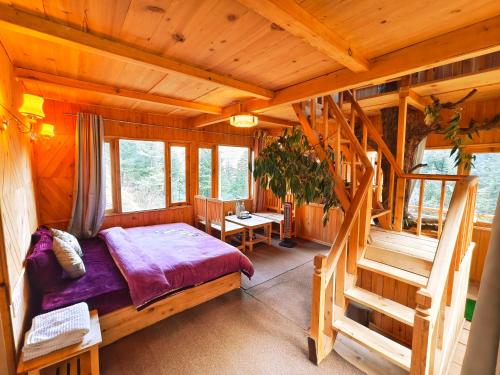 a bedroom in a log cabin with a bed and stairs at Lambri View Treehouse Jibhi in Jibhi