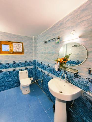 a blue bathroom with a sink and a toilet at Lambri View Treehouse Jibhi in Jibhi