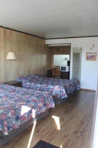 um quarto de hotel com duas camas e uma cozinha em Raval Paradise Motel and RV Park em Youngstown