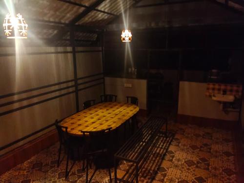 a room with a table and chairs and lights at Green Leaf in Padinjarathara