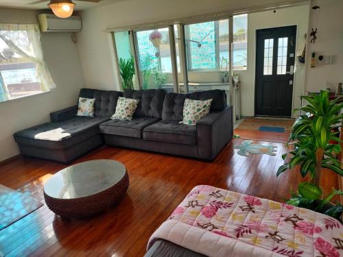 a living room with a couch and a coffee table at ほぬのいえ Honu's house in Uruma