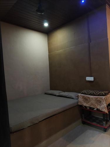 a room with a bed and a chair in it at janaki Homestay in Gokarna