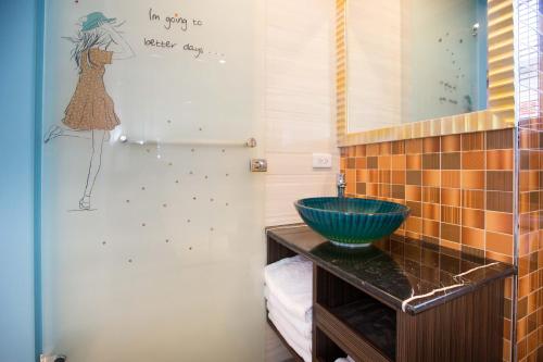 a bathroom with a sink and a wall with a woman painted on it at Diudiu Dang Paternity B&B in Dongshan