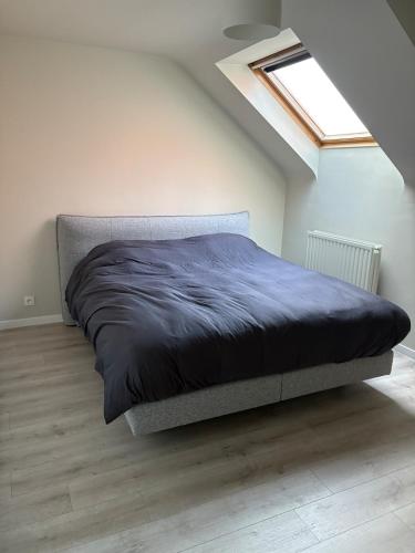 a bed in a white room with a window at Spacious duplex apartment in Overijse in Overijse