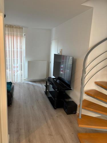 a living room with a flat screen tv and a staircase at Spacious duplex apartment in Overijse in Overijse