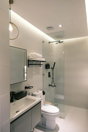 a white bathroom with a toilet and a shower at Casa Marcos Resort and Villas in Pastrana
