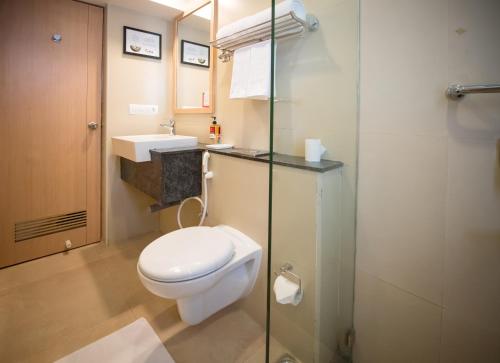 a bathroom with a toilet and a glass shower at Red Fox Hotel, Trichy in Tiruchchirāppalli