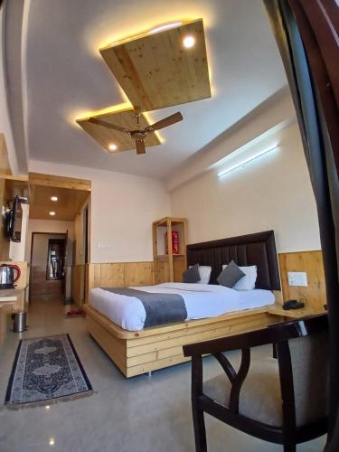 ein Schlafzimmer mit einem Bett und einem Deckenventilator in der Unterkunft Hotel Cloud Hills in Dharamsala