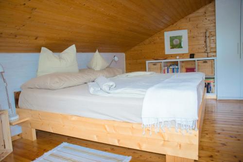 a bedroom with a large bed in a wooden room at Die Naradhube Ferienwohnungen Wolte in Abriach