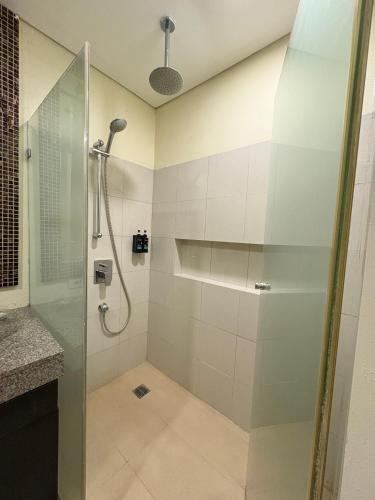 a shower with a glass door in a bathroom at Carola Pico De Loro in Nasugbu