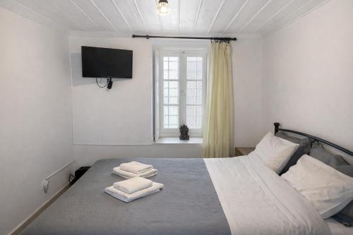 a bedroom with a bed with two towels on it at Lemon House in Hydra