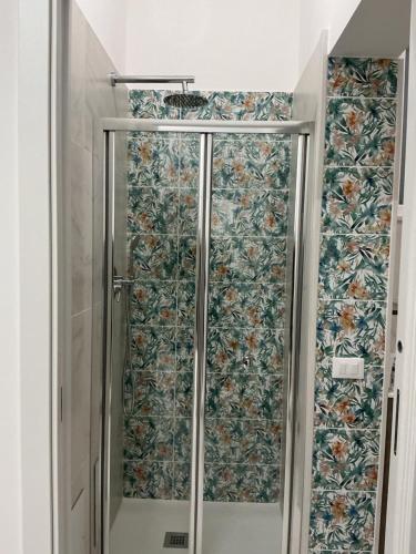 a shower in a bathroom with floral wallpaper at Crispi Accomodation B&B in Catania