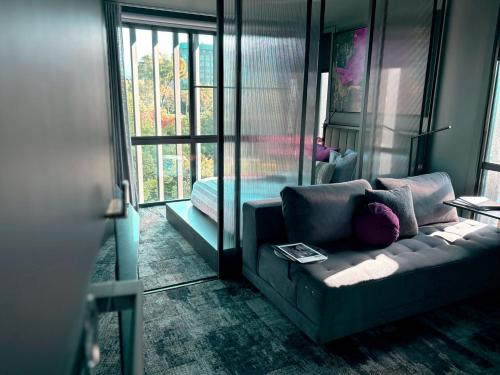 a living room with a couch and a window at Green Rooms Braddon - Designer Micro Apartments in Braddon