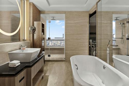 a bathroom with a tub and a sink at Suzhou Marriott Hotel in Suzhou