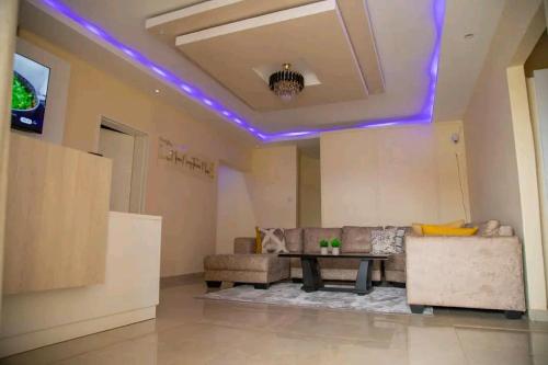 a living room with purple lights on the ceiling at Pamusha Motel in Ngesi