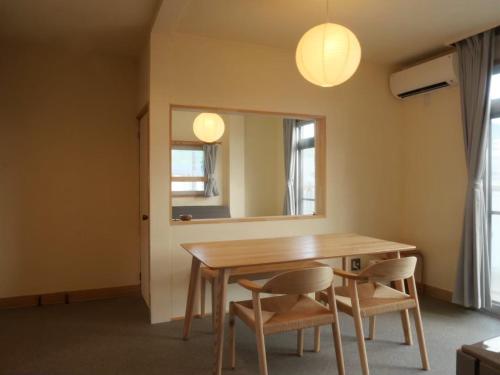 a dining room table with two chairs and a mirror at HITOYANE guesthouse-1日1組限定- in Aizuwakamatsu