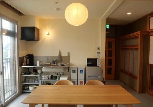 a dining room with a wooden table and chairs at HITOYANE guesthouse-1日1組限定- in Aizuwakamatsu