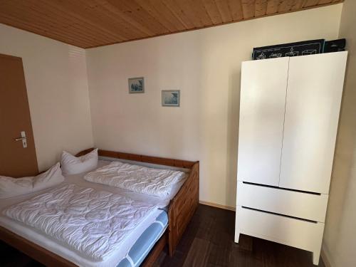 a bedroom with a bed and a white cabinet at Bungalow Beate in Zinnowitz