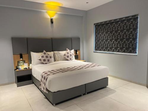 a bedroom with a large white bed with pillows at Ramanashree California Resort in Yelahanka