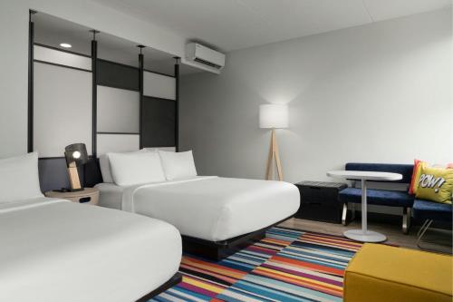 a hotel room with a bed and a couch at Aloft by Marriott Richmond West Short Pump in Short Pump