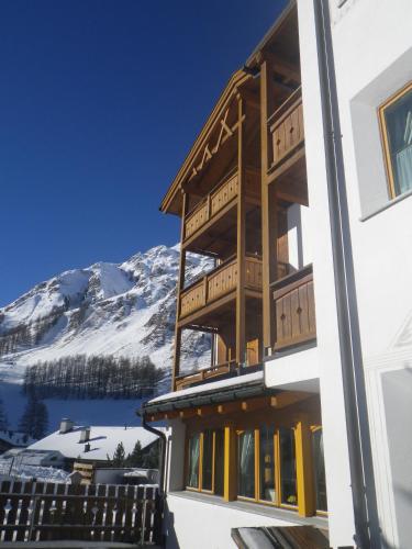 a building with a mountain in the background at Apart-Garni Motnaida in Samnaun