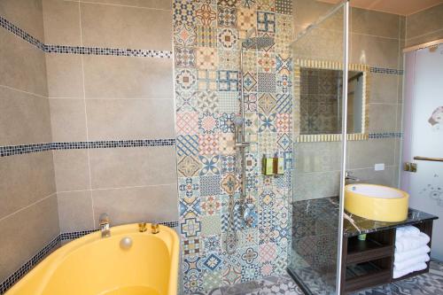 a bathroom with a shower with a yellow tub at Diudiu Dang Paternity B&B in Dongshan