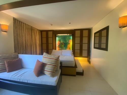 a hotel room with two beds and a couch at Carola Pico De Loro in Nasugbu