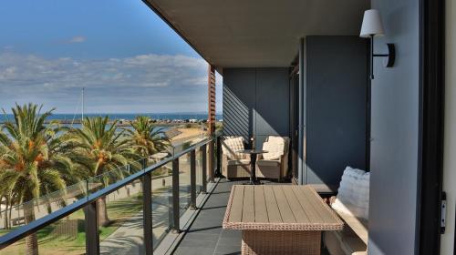 a balcony with a bench and a view of the beach at Beach paradise in Werribee South