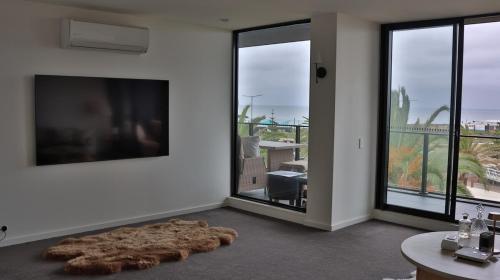 a living room with a large brown rug on the floor at Beach paradise in Werribee South