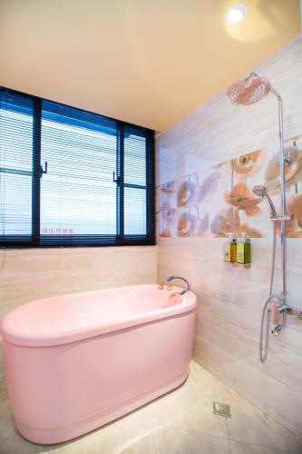 a pink bath tub in a bathroom with a window at Diudiu Dang Paternity B&B in Dongshan