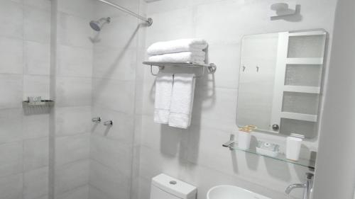 a white bathroom with a toilet and a mirror at MAKEYA Home-Hotel in Churín