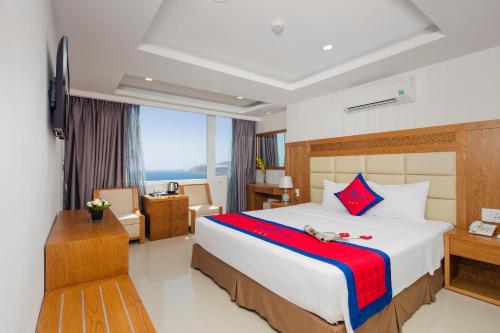 a hotel room with a large bed and a desk at Sun City Hotel in Nha Trang