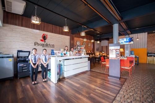 two people standing at a counter in a restaurant at Prajaktra City Hostel in Udon Thani