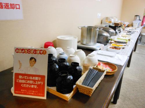 a long table with a counter with food on it at Hotel Kimitsu Hills in Kimitsu