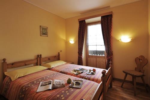 een slaapkamer met een bed met een tafel en een raam bij Stella Alpina - Happy Rentals in Livigno