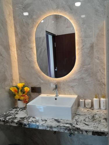 a bathroom with a white sink and a mirror at Villa KARISMA Candidasa in Candidasa