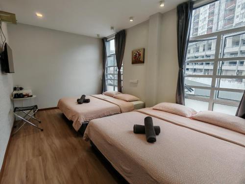 three beds in a room with a large window at Snooze TOO in Brinchang
