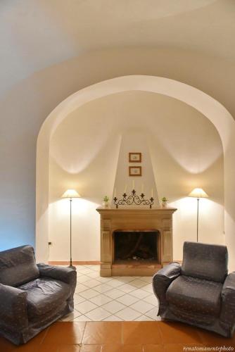 a living room with two chairs and a fireplace at Hotel Garden Riviera in Santa Maria di Castellabate