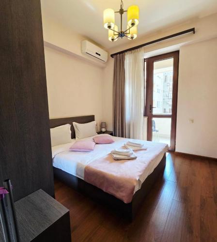 a bedroom with a bed with pink pillows on it at Republic square LUXURY with balcony in Yerevan