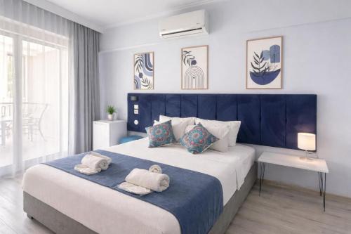 a bedroom with a large bed with towels on it at Akman City Hotel in Kuşadası