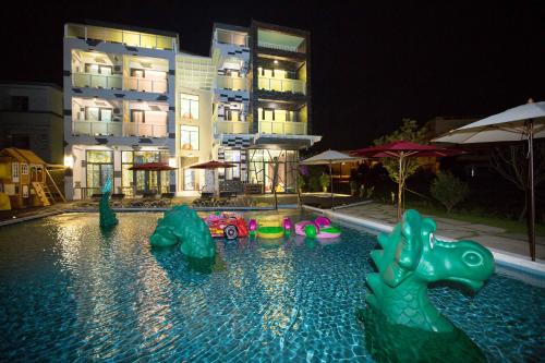 a swimming pool with a water slide in front of a building at Diudiu Dang Paternity B&B in Dongshan