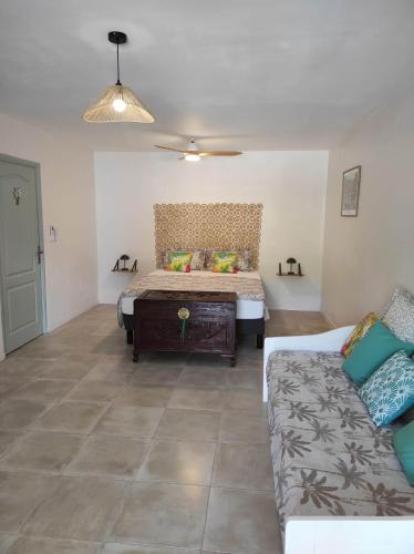 a living room with a bed and a couch at La Palmeraie Créole in Sainte-Marie