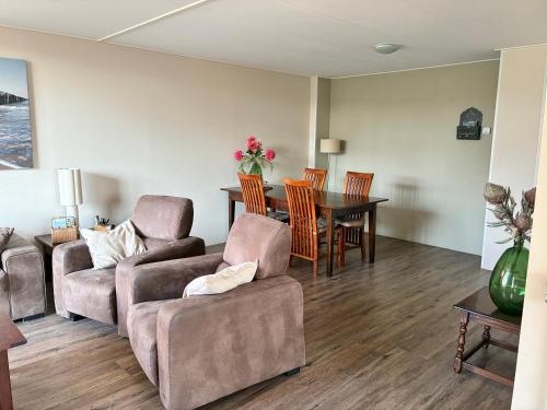 a living room with a couch and a table at Vakantiewoning Meeuw in Hollum