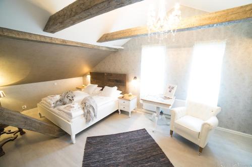 a bedroom with a bed and a chair and a window at Vaihmalan Hovi in Lempäälä