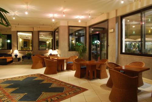 a lobby with tables and chairs in a building at UNAHOTELS Imperial Sport Hotel in Pesaro