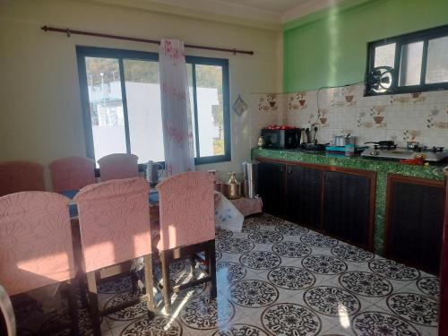 una cucina con un tavolo con sedie rosa di Silwal Home a Kathmandu