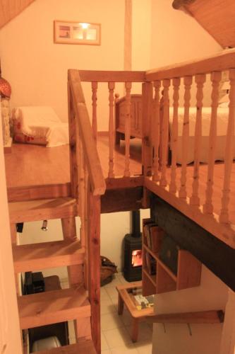 a wooden staircase leading to a room with a bed at Les rives de Champagne in Courceroy