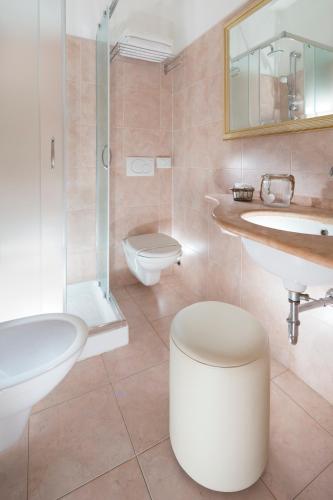 a bathroom with a toilet and a sink and a shower at Hotel Apollo in Riccione
