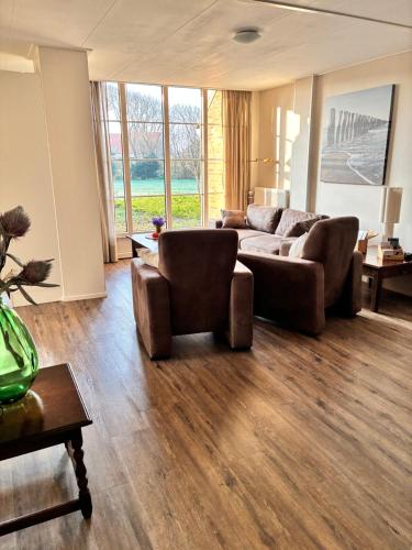 a living room with a couch and a table at Vakantiewoning Meeuw in Hollum